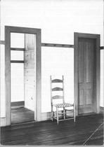 SA0641 - Photo of a side chair shown between two doors and a built-in cupboard with drawers seen through a doorway., Winterthur Shaker Photograph and Post Card Collection 1851 to 1921c